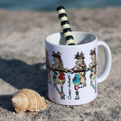 Lustige Tasse Motiv "Wilde Pferde" von den Crazy-Animals im Sand mit Muschel fotografiert