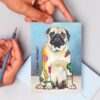 Die lustige Postkarte zeigt einen sitzenden Mops mit unwiderstehlichem lieben Hundeblick. Sein Fell ist mit bunten Farbornamenten, pointiert platziert, wie geometrische Tatoos, gestaltet. Die Postkarte ist mit Liebe designed von der Regensburger Künstlerin Sabine Leipold.